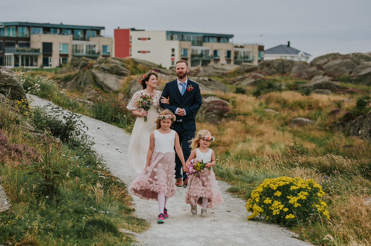 Brudeparet og blomsterpikene ankommer vielsested på stranda i Haugesund - utendørs sommerbryllup på Vestlandet