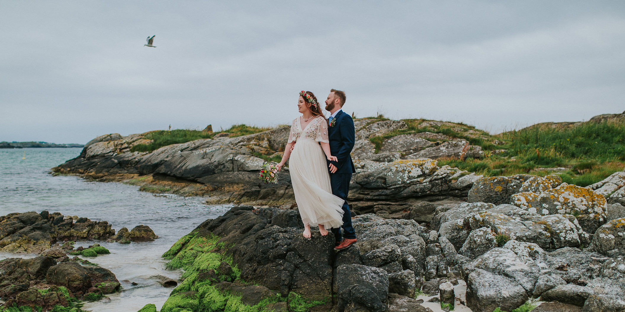 brudepar på mosekledde svaberg på en nydelig strand i Haugesund - sommerbryllup på Vestlandet