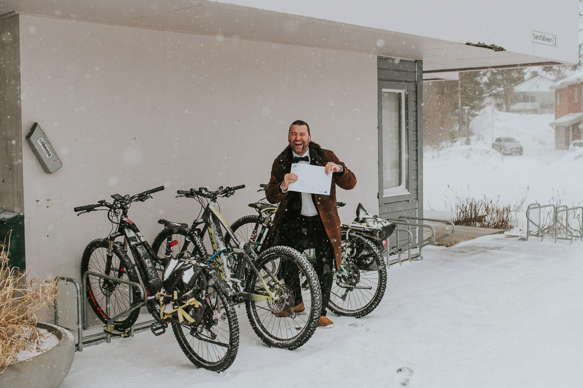 A groom laughing under a heavy blizzard in Norway