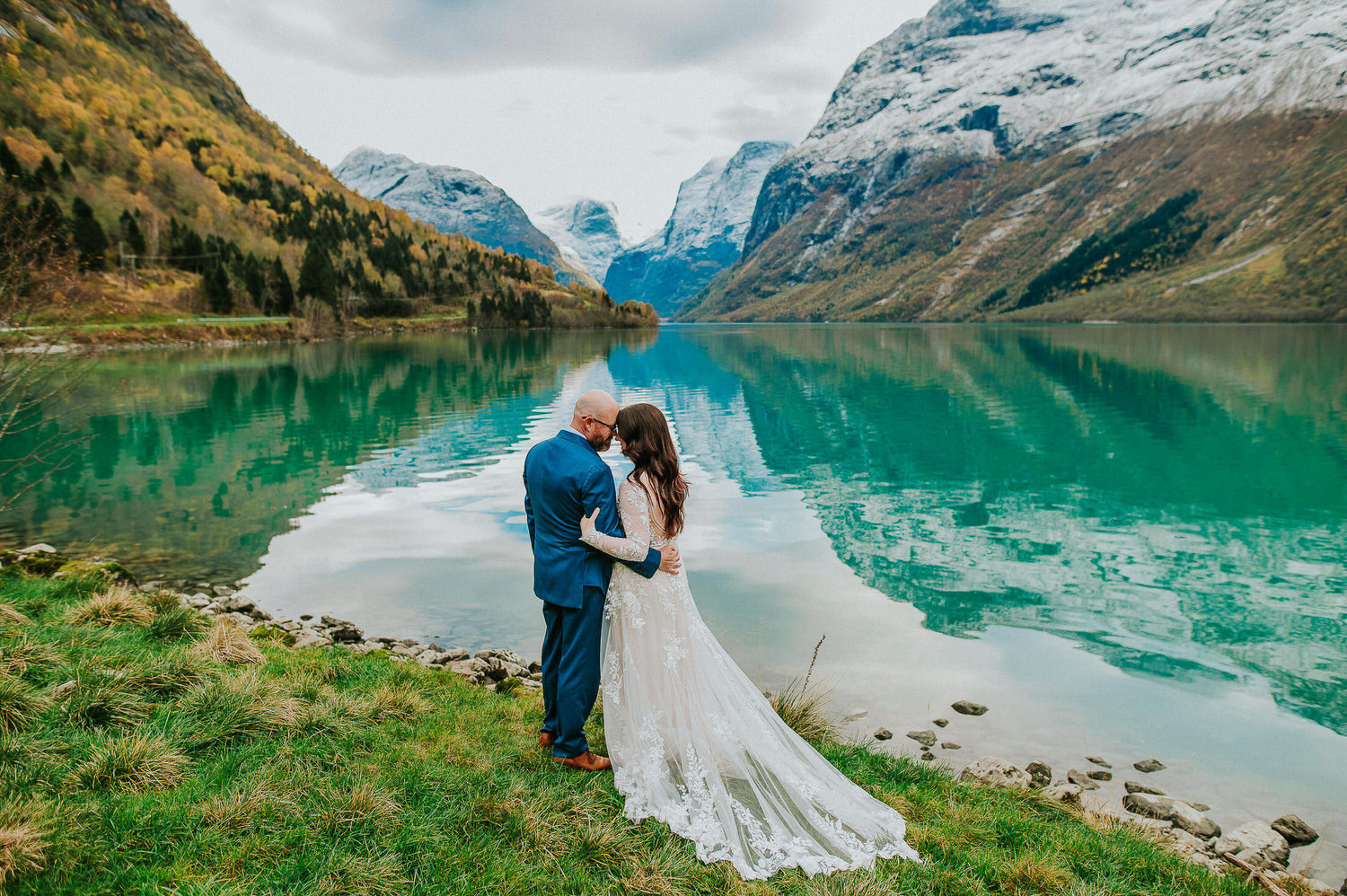 Bride and groom portraits by a stunning glacier lake Lovatnet in Loen Norway on the day of their adventure elopement