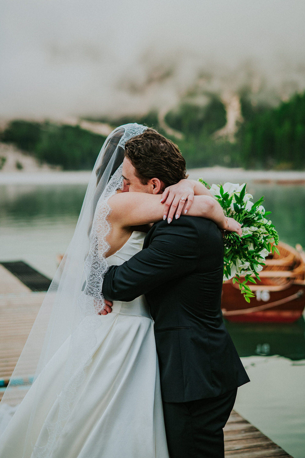 Bride and groom hugging each other in front of a beautiful lake in Dolomites Italy