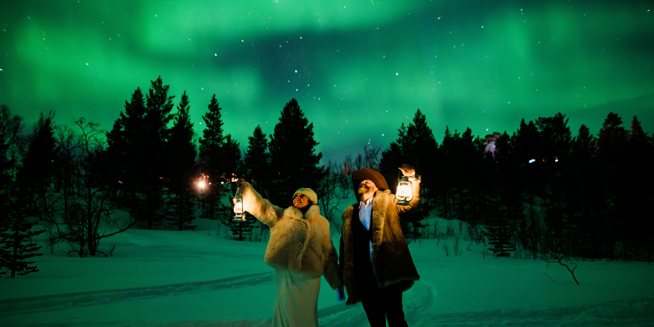 An intimate northern lights destination wedding in Norway Alta - beautiful bride and groom under aurora borealis in a forest