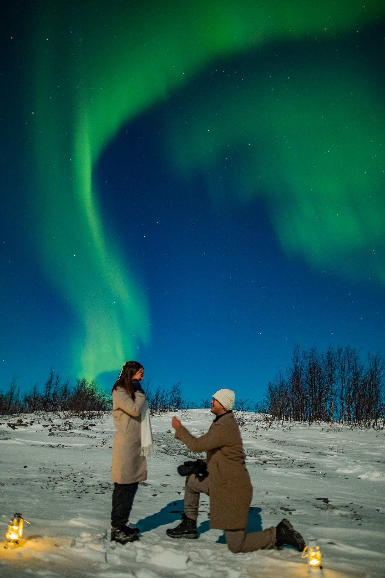 A guy went down on his knee and proposing to his girlfriend in Alta Norway under the northern lights