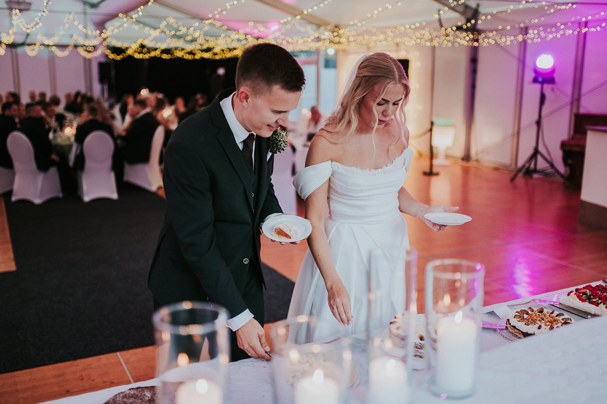 Bryllupsfest i en festlokale Nordlyssal i Kvenvik utenfor Alta på på sensommer - brudeparet skjærer bryllupskaken