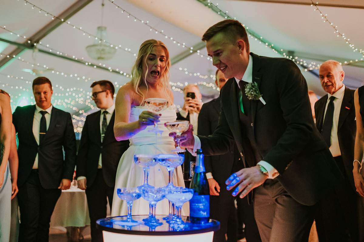 Stemningsfull bryllupsfest i Kvenvik Alta på sensommer - brudepar drikker fra champagne tårn og deler ut glassene til gjestene sine