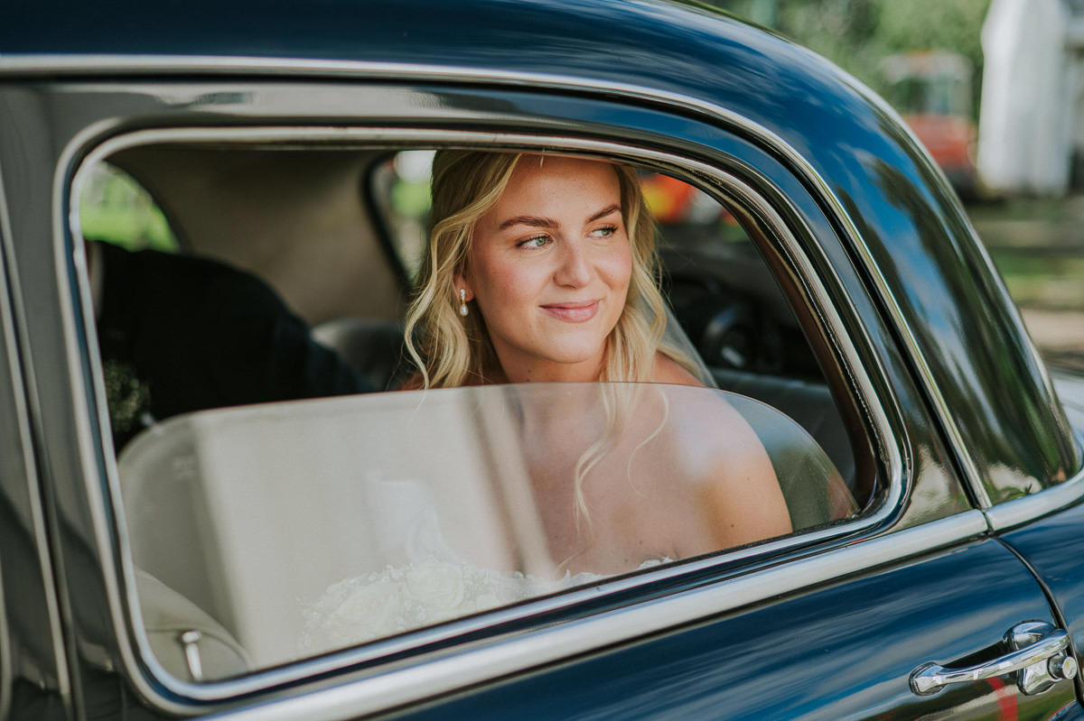 Bruden i en retro bil ser ut vinduet