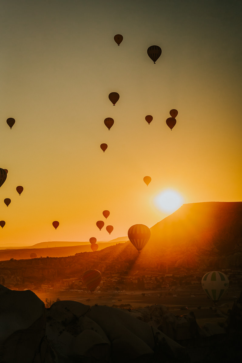 Stunning sunrise in Cappadocia Turkey with hundreds hot air balloons floating in the sky - captured by photographer TS Foto Design