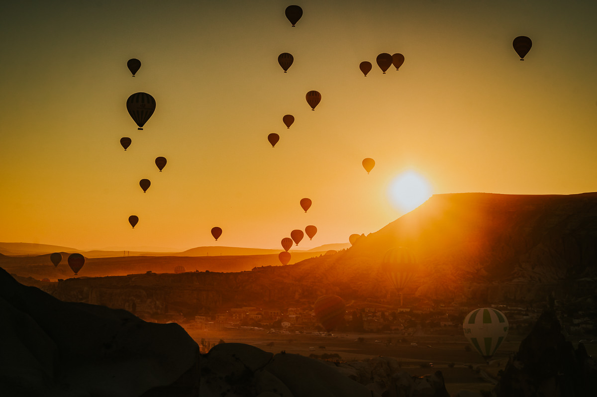 Stunning sunrise in Cappadocia Turkey with hundreds hot air balloons floating in the sky