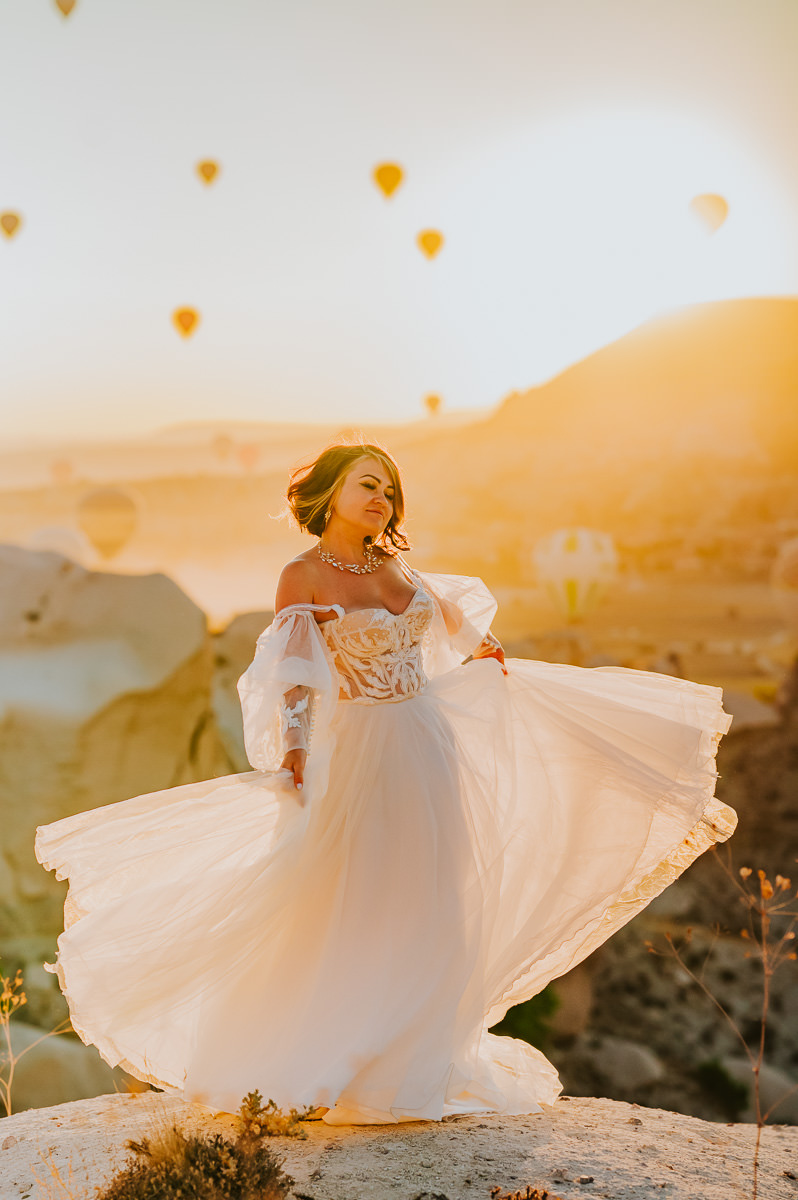 Stunning bride swirling in her wedding gown in Cappadocia Turkey at sunrise on the day of her adventure elopement
