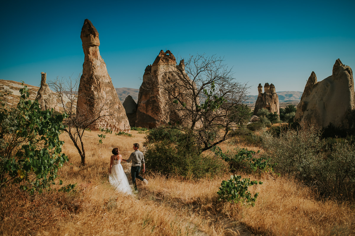 Bride and groom walking in Love Valley on the day of their Cappadocia elopement wedding in Turkey - captured by Europe wedding photographer TS Foto Design