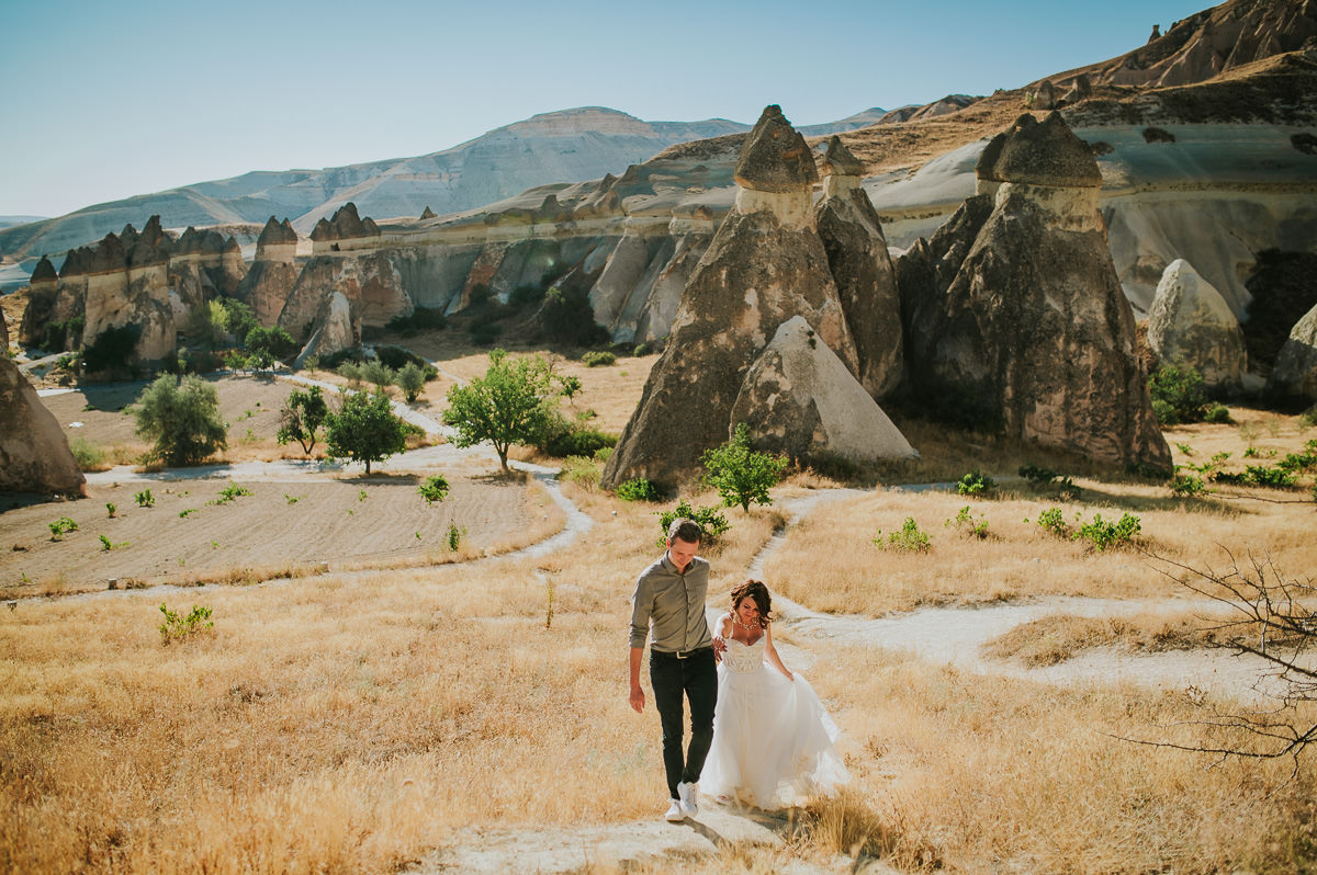 Bride and groom walking in Love Valley on the day of their Cappadocia elopement wedding in Turkey - captured by Europe wedding photographer TS Foto Design