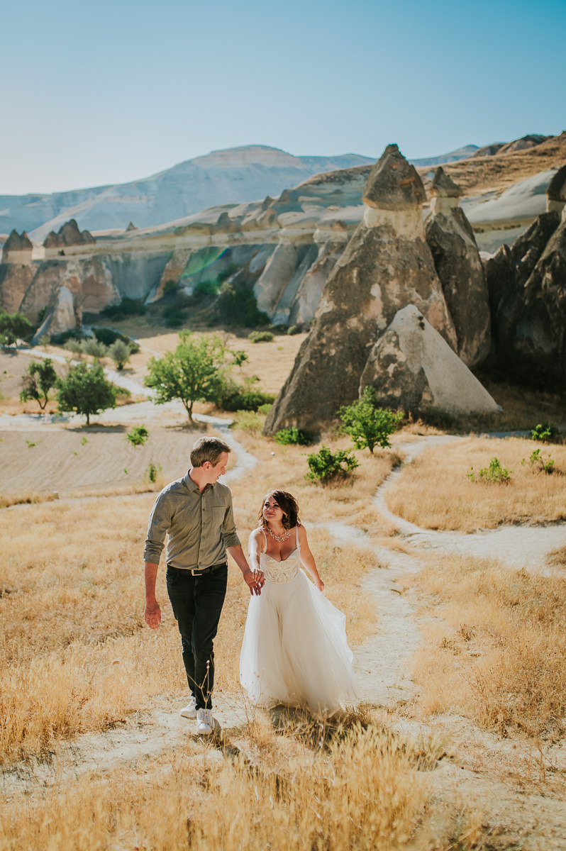 Bride and groom walking in Love Valley on the day of their Cappadocia elopement wedding in Turkey - captured by Europe wedding photographer TS Foto Design