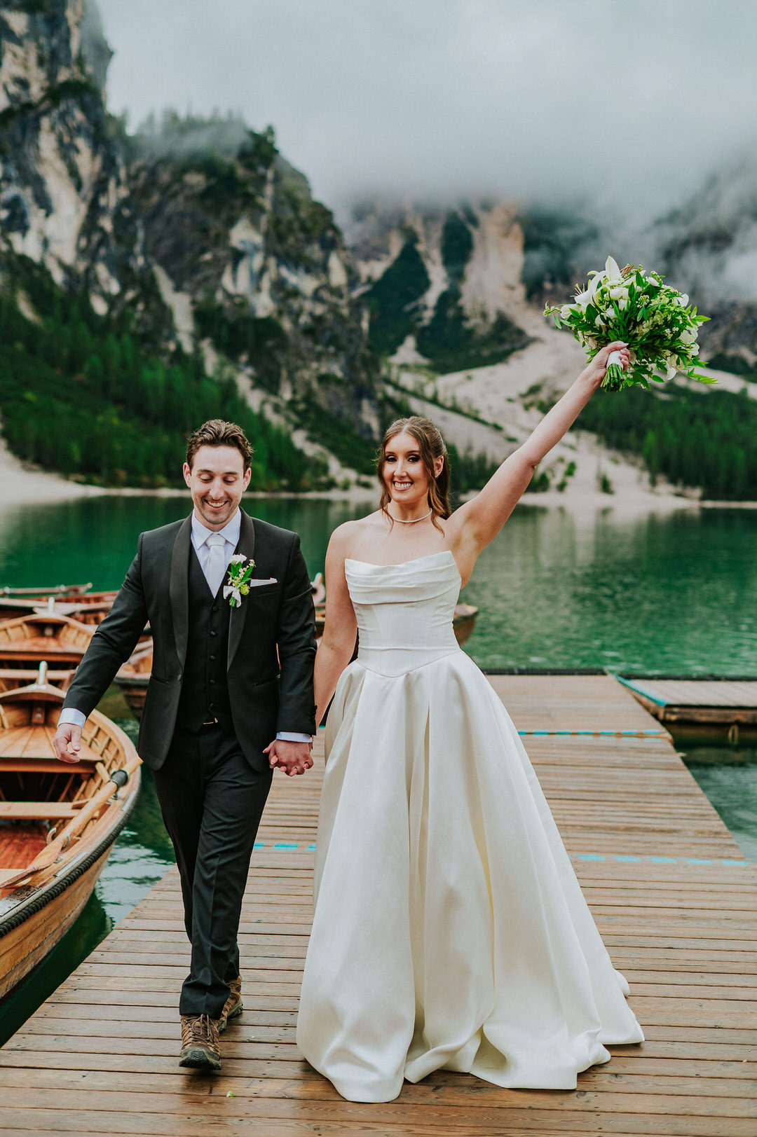 Epic portrait of a bride and groom at the boathouse on Lago di Braies in the Italian Dolomite - captured by elopement photographer TS Foto Design