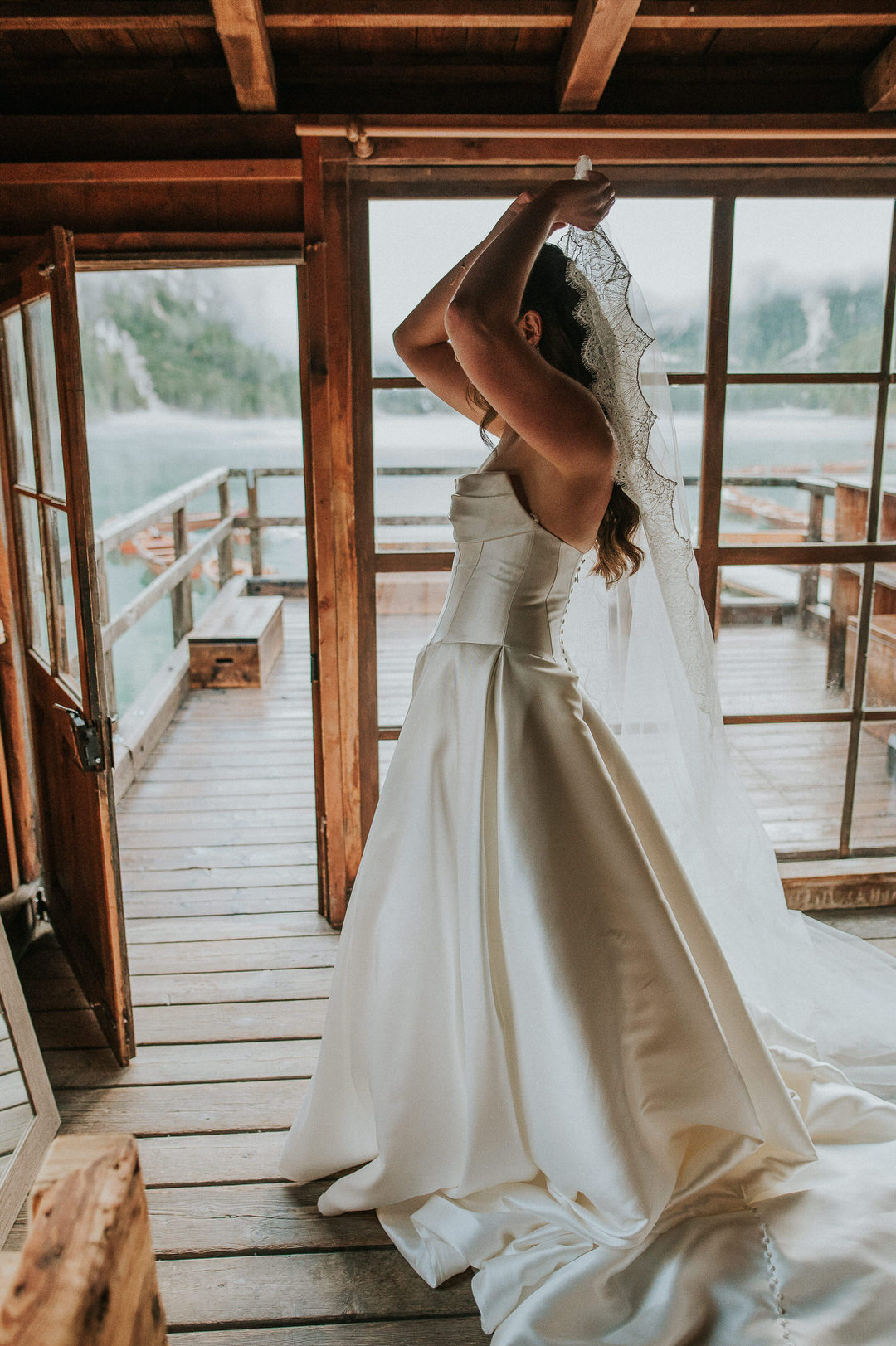 Beautiful bride getting ready in a boathouse at Lago di Braies in the Italian Dolomites