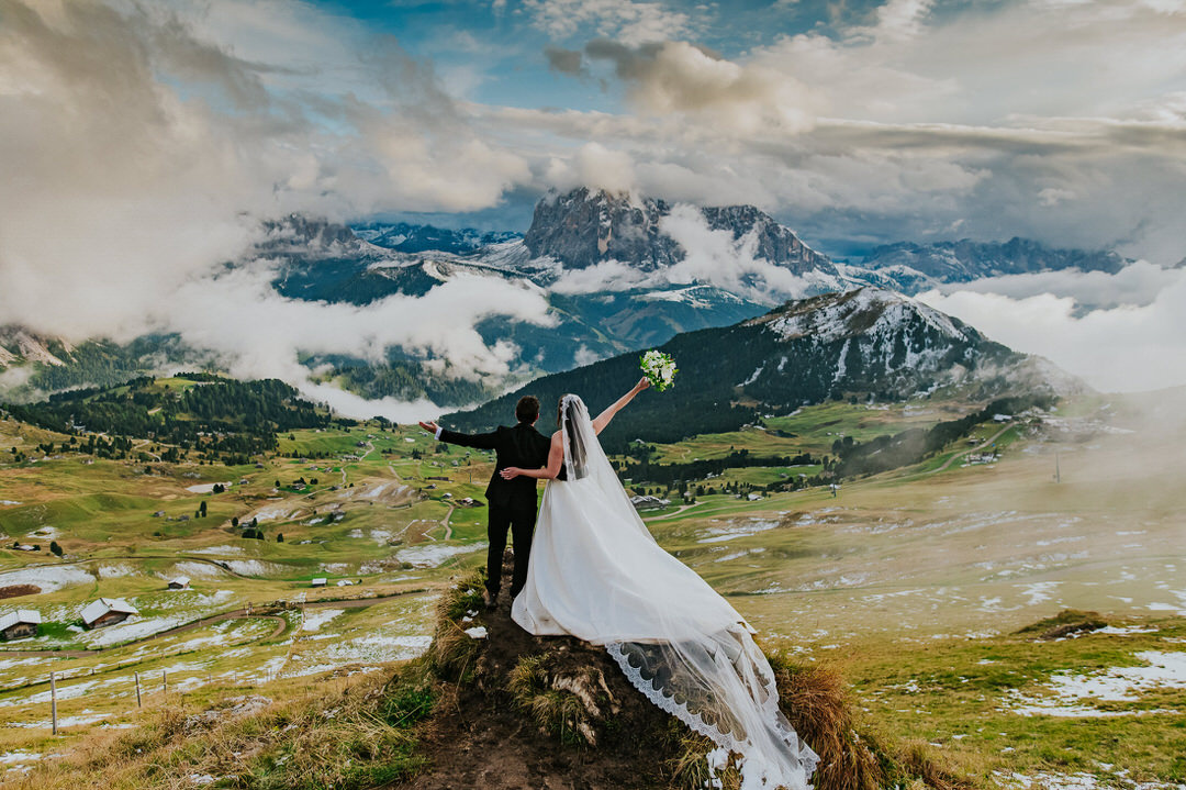 Stunning bride and groom portrait on Seceda mountaintop at sunset with dramatic sky - captured by Dolomites elopement photographer TS Foto Design
