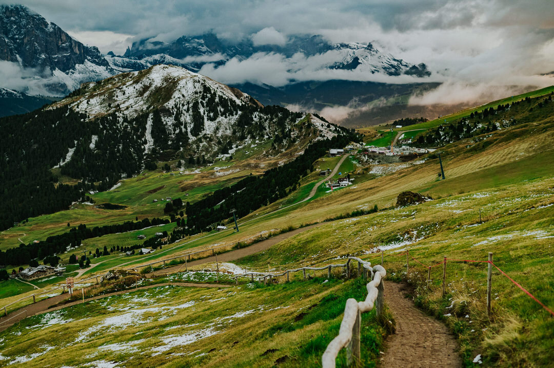 Landscape photograph of rolling clouds on a Seceda mountaintop in the Italian Dolomites