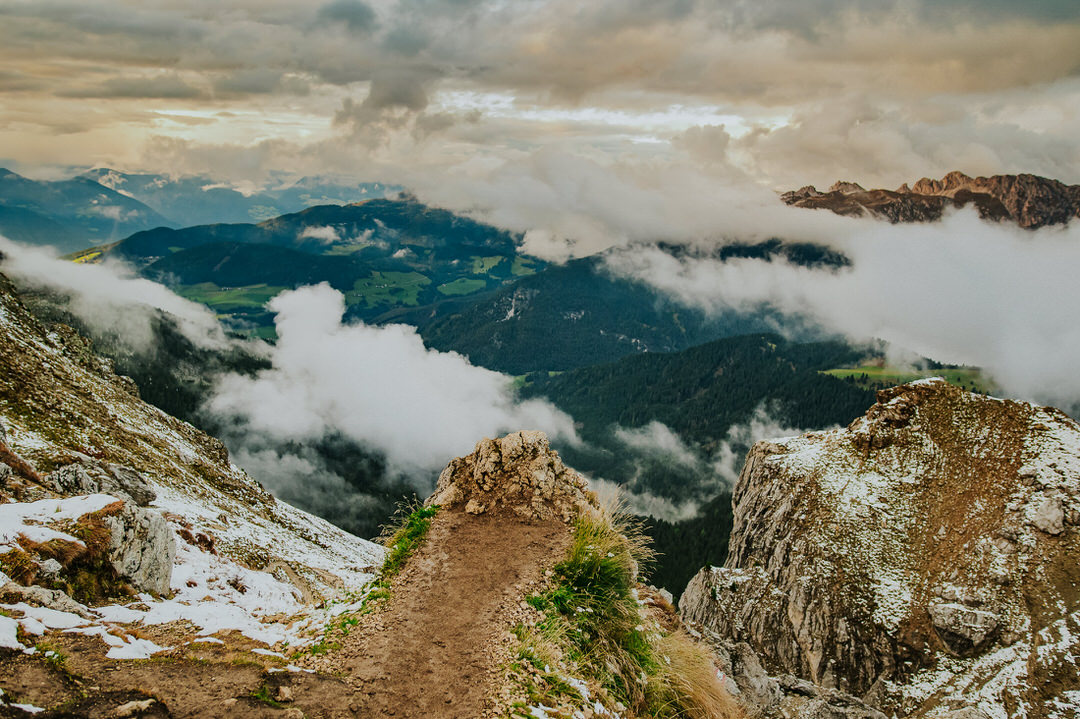 Landscape photograph of rolling clouds on a Seceda mountaintop in the Italian Dolomites