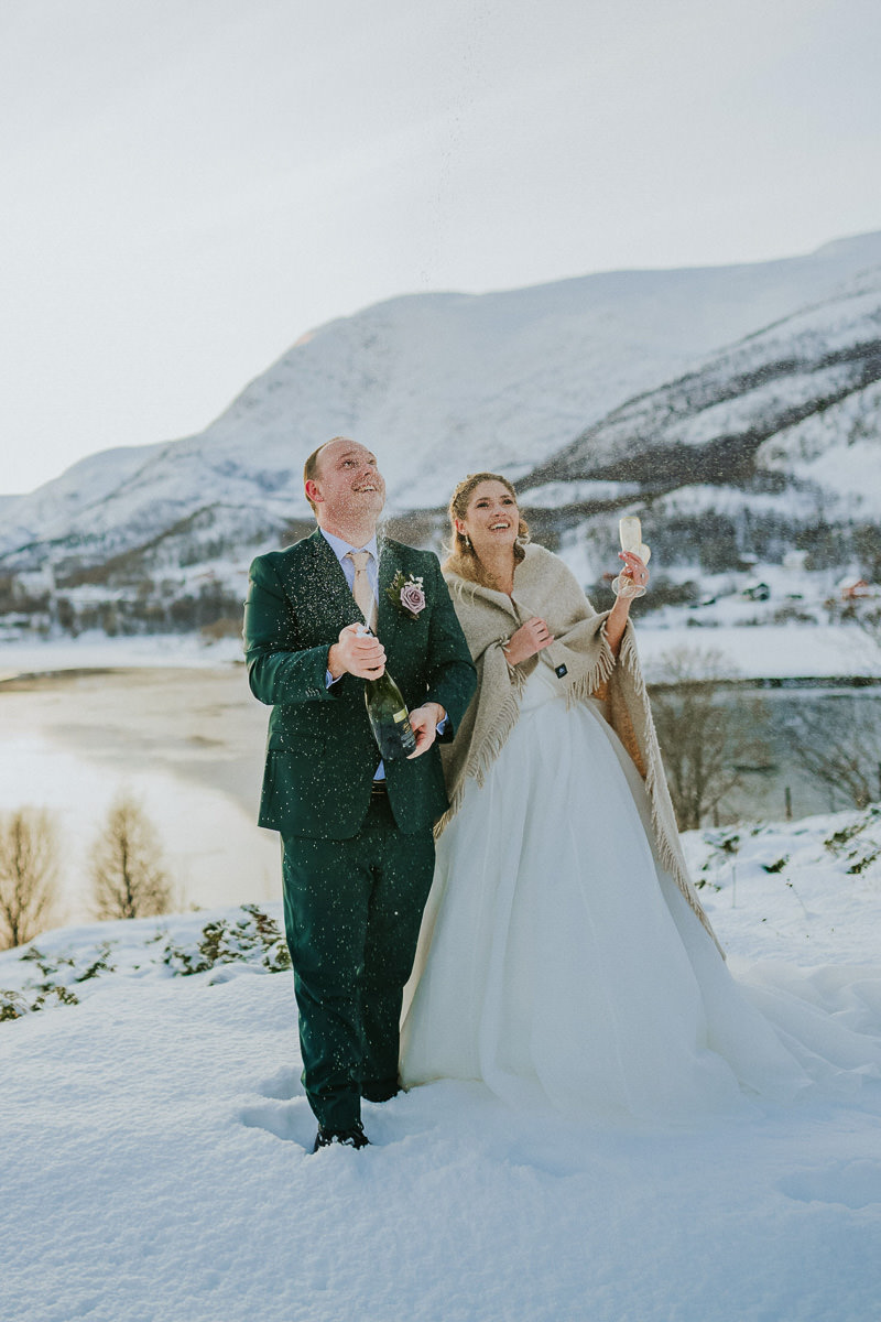 Bride and groom doing a champagne toast on the day of their winter elopement in Alta Norway 