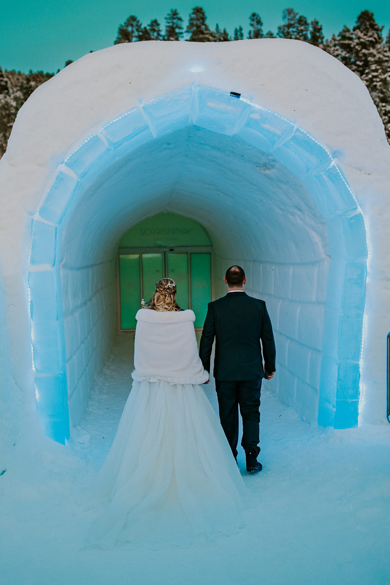 Bride and groom walking in the igloo hotel Sorrisniva in Alta Norway