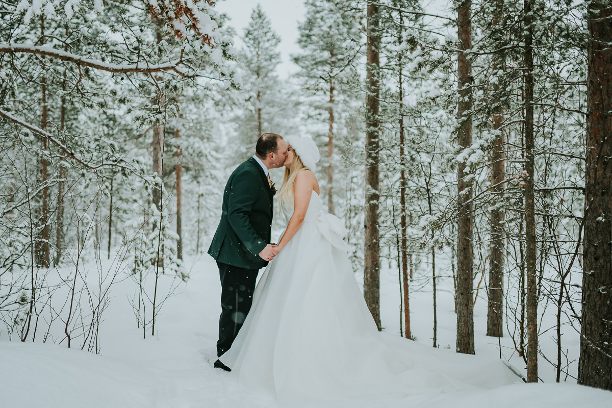 Bride and groom portrait in a snow covered forest 