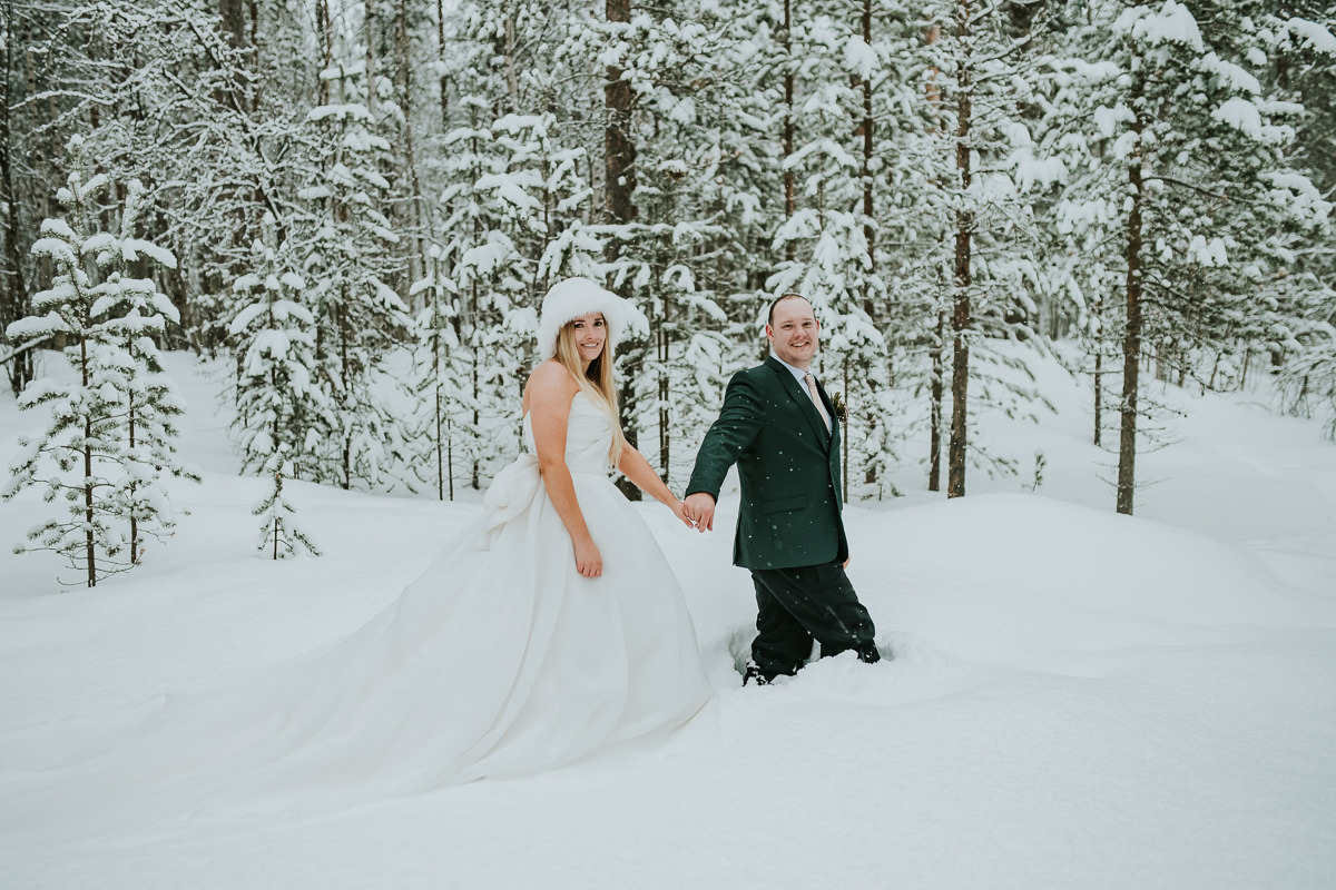 Bride and groom portrait in a snow covered forest 