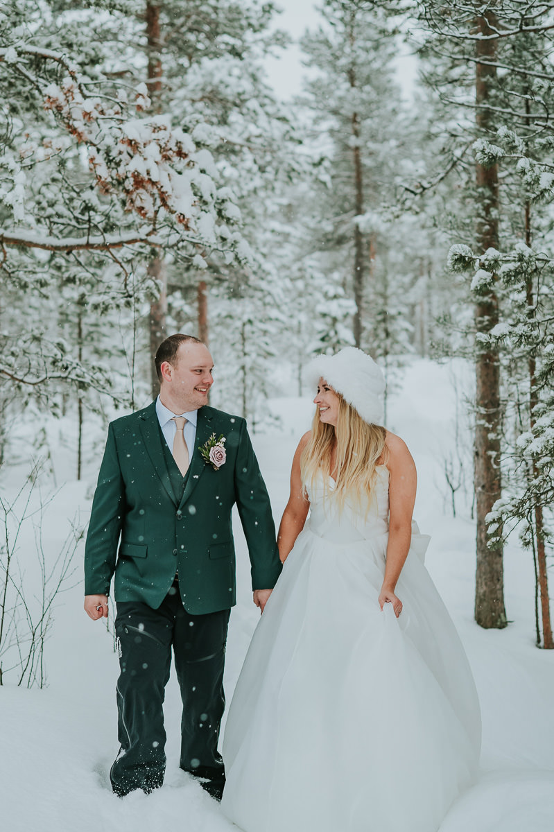 Bride and groom portrait in a snow covered forest on the day of their arctic winter elopement in Alta Norway