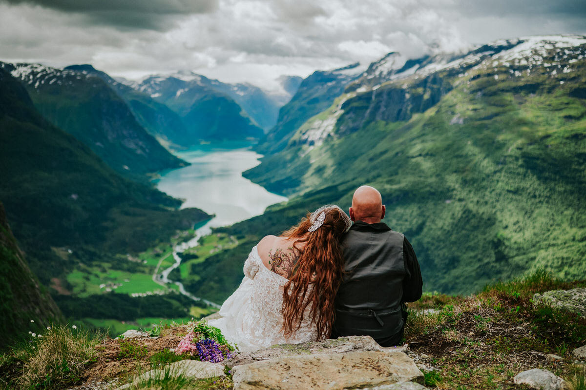 Bride and groom portrait on a mountaintop Hoven in Loen Western Norway - adventure elopement day - overlooking the glacier lake Lovatnet and the mountains around