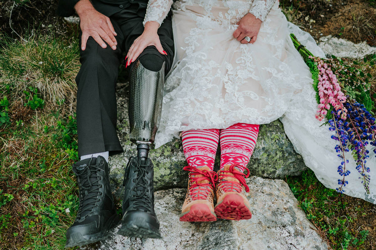 Groom with a prosthetic leg and bride wearing hiking boots for their adventure elopement day in Norway