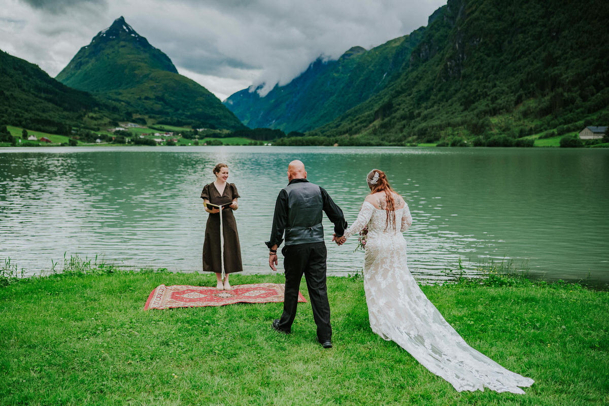 Bride and groom walking towards their elopement ceremony location beneath mountain Eggenipa in Western Norway