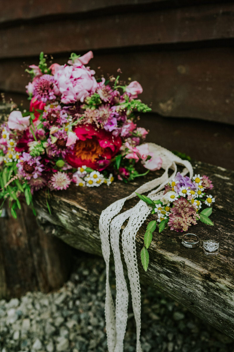 Beautiful wedding stationery with rings, burgundy bouquet and lace