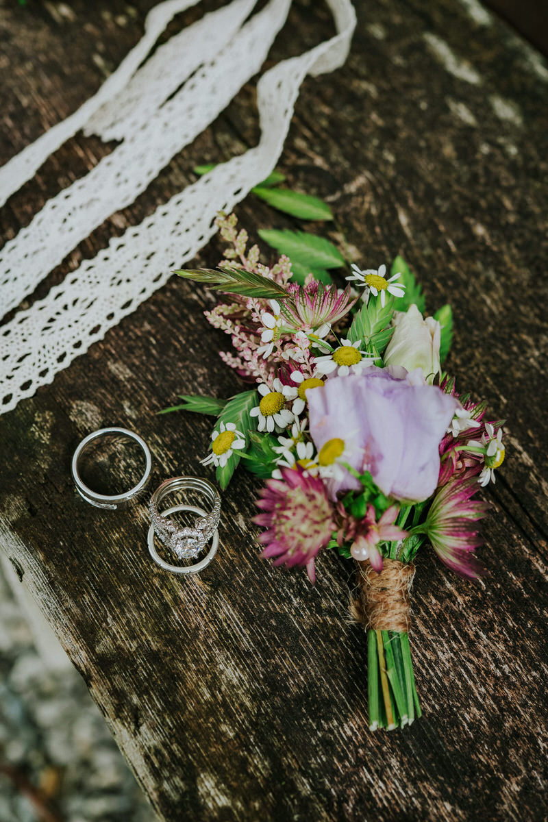 Pink and purple buttoniere and wedding rings 