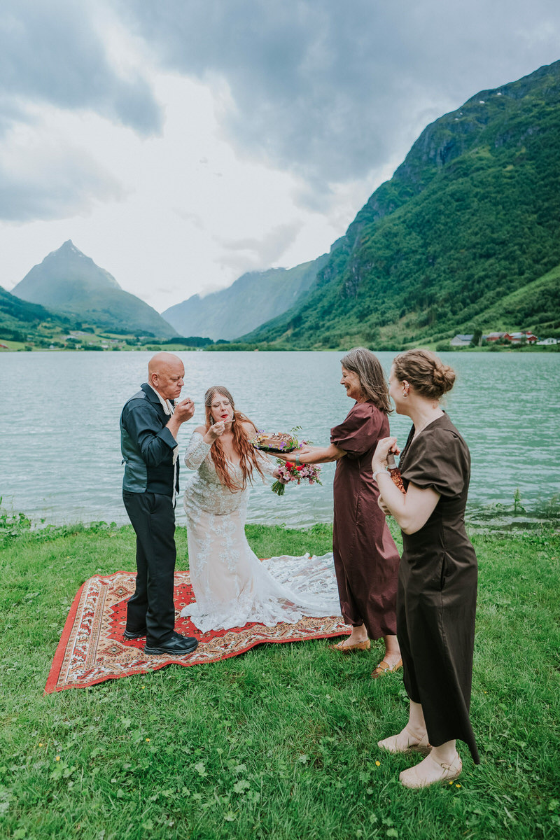 Bride and groom eating their wedding cake outside among norwegian mountains