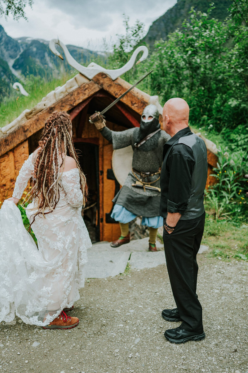 Bride and groom talking to a viking in Gudvangen Njardarheimr village on the day of their adventure viking wedding in Norway