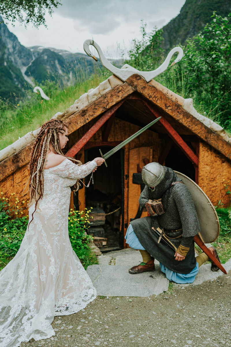 Bride and groom talking to a viking in Gudvangen Njardarheimr village on the day of their adventure viking wedding in Norway