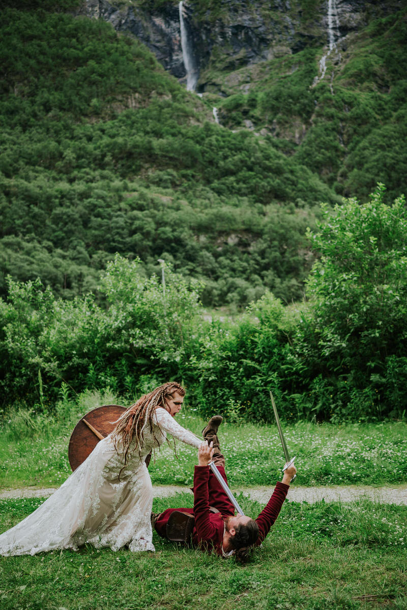 Bride with viking-inspired hair style and braids fighting a viking in Njardarheimr Gudvangen Norway