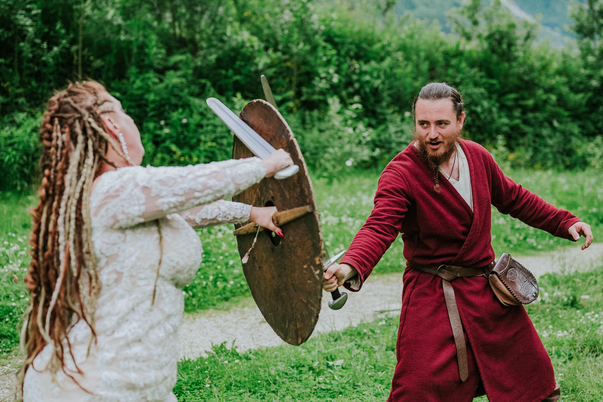 Bride with viking-inspired hair style and braids fighting a viking in Njardarheimr Gudvangen Norway