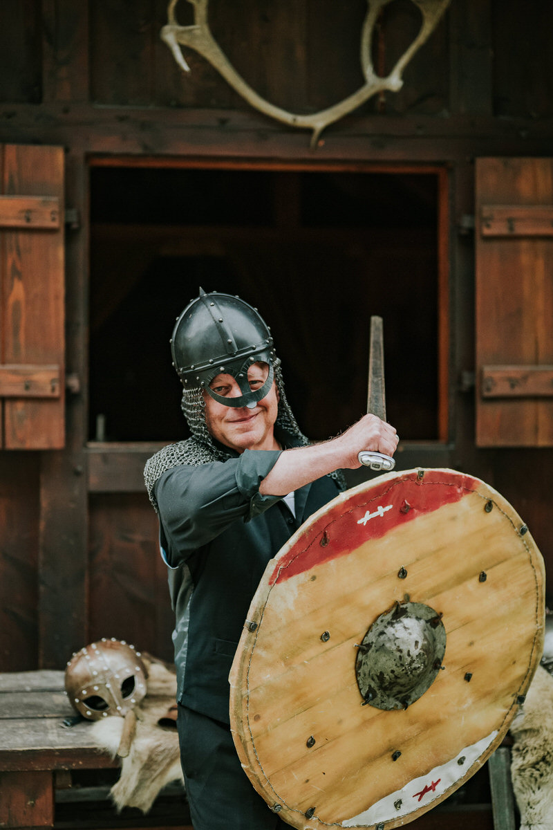 Viking groom posing with a sword and shield in Gudvangen viking village